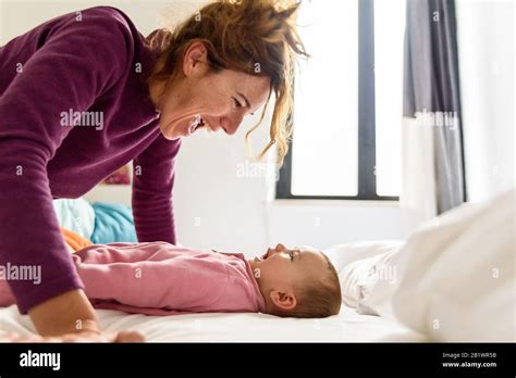 Single Mother Waking Up Her Baby Lying On The Bed Making Gestures Of