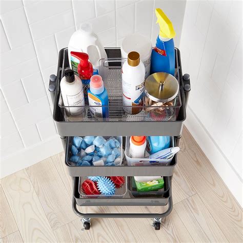 A Metal Cart Filled With Cleaning Supplies On Top Of A Wooden Floor
