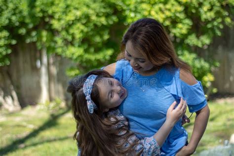 Latina Mother And Daughter Smiling And Laughing Outside In Back Yard