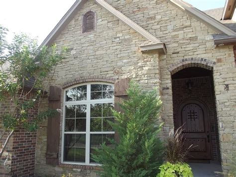 stacked stone, wood shutters, dark red brick | Stone ...