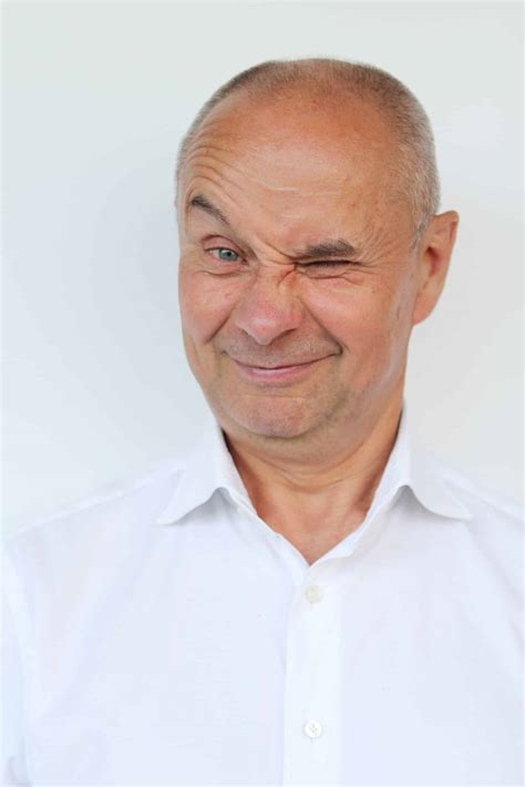 Bald Old Man In A White Shirt Showing Grimaces Winks Smiling Close