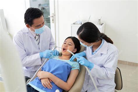 free photo asian male dentist and female nurse treating cavity in clinic