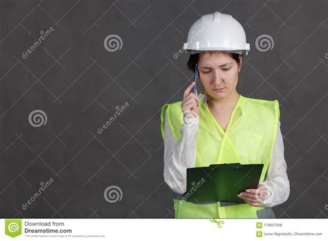 Young Woman Engineer In Protective Helmet And Vest With