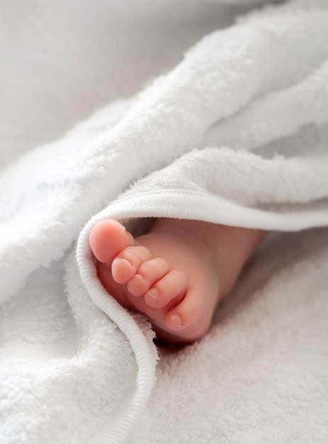 Premium Photo Newborn Baby Foot Emerging From White Softness