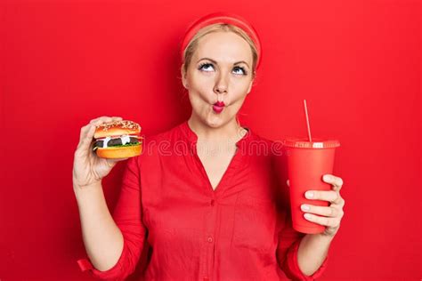Young Blonde Woman Eating A Tasty Classic Burger With Fries And Soda