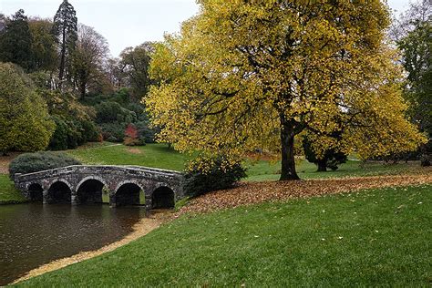 A Stone Bridge Over A River In A Park