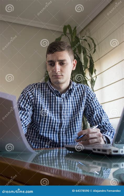 Young Business Man Reading Some Papers At Home Office Stock Photo