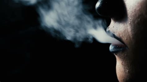 Man Smoking A Cigarette Close Up On A Black Background