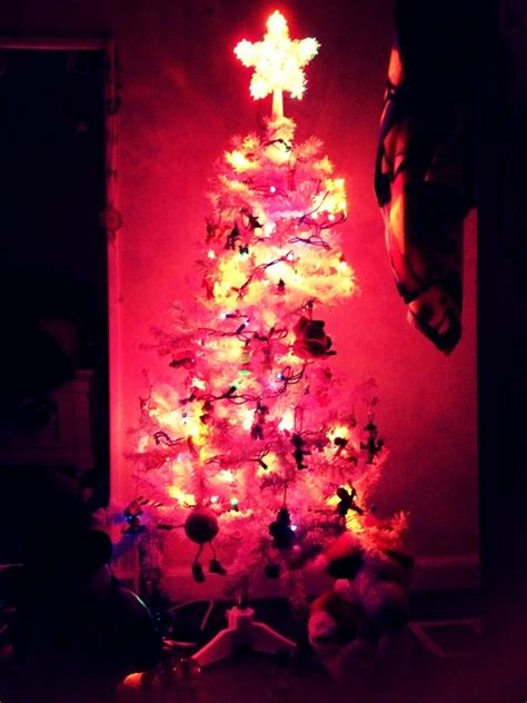 A Lit Christmas Tree In The Corner Of A Room