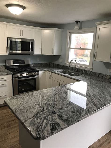 The stove has a black cooktop. Silver cloud granite (With images) | Granite countertops ...