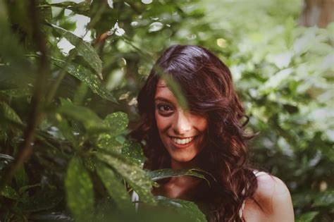 Premium Photo Portrait Of Smiling Young Woman Standing Amidst Plants