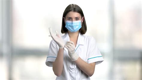 lady doctor putting on protective gloves beautiful female doctor in face mask preparing for