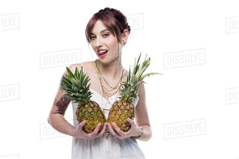 Sensual Young Woman Holding Ripe Pineapples And Looking At Camera Isolated On White Stock