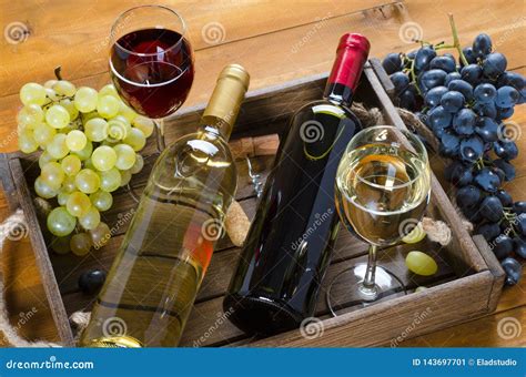 Duas Garrafas Vidros Do Vinho Grupos De Uvas Na Caixa De Madeira