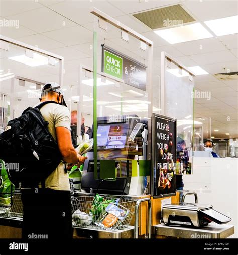 male shopper paying for shopping at a self service till in john lewis waitrose supermarket stock