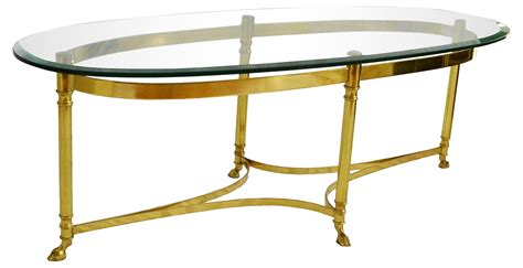 Imagine a brass coffee table in the middle of living room. Labarge oval brass cocktail table with dramatic hoof feet ...