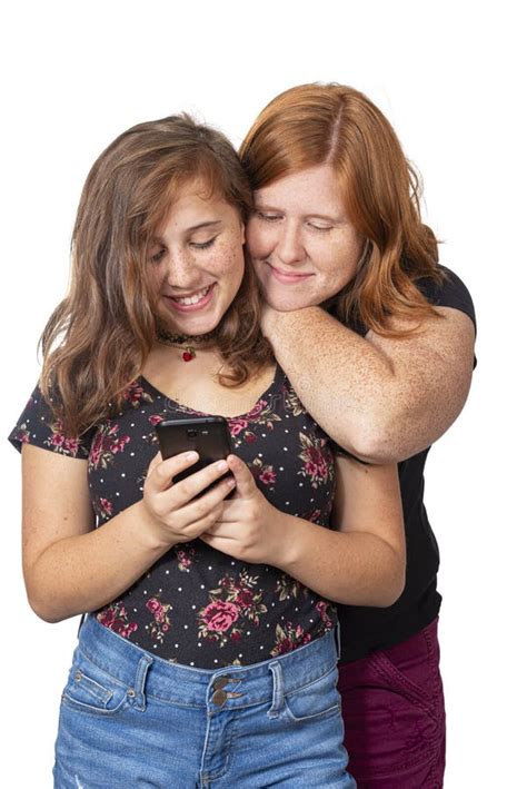 Mor Och Dotter Skrattar När De Tittar På Mobiltelefon Arkivfoto Bild