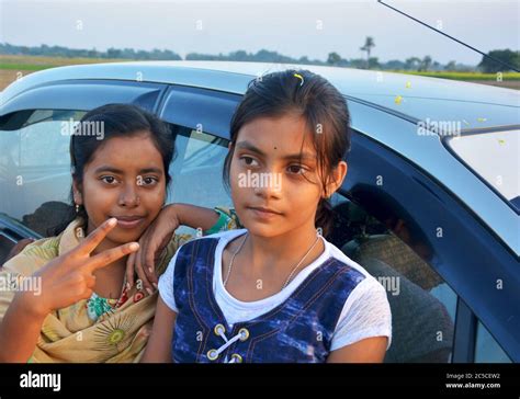 Two Beautiful Indian Teenage Girls Standing With Car Showing Victory