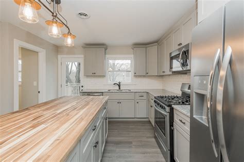 Gray cabinets with butcher block and granite counter tops. mixed metal