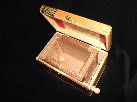 A puzzle box can be opened by moving the sliding pieces of its surfaces. Cigar Box Puzzle #3