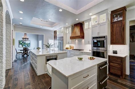 Scandinavian kitchen with kitchen island wood countertop. Beautiful kitchen with White and Walnut cabinets, two ...