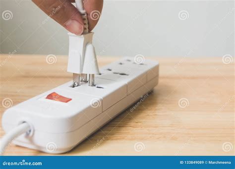 Hand Of Male Or Female Unplugged Plug Into Socket To Save Energy