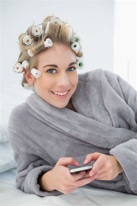 Joyful Relaxed Blonde Woman In Hair Curlers Buying Online With Her