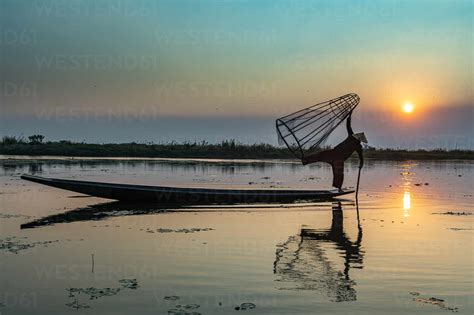 Fisherman At Inle Lake With Traditional Intha Conical Net At Sunset