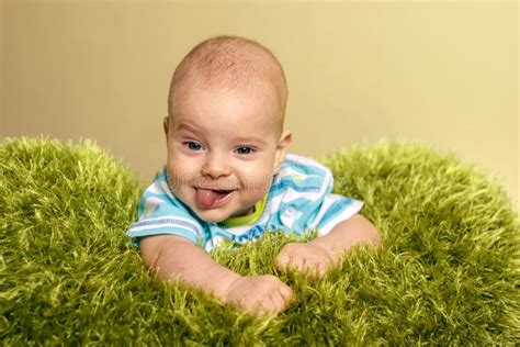 Portrait Of Young Innocent Smiling Baby Small Boy Lies On Knitted