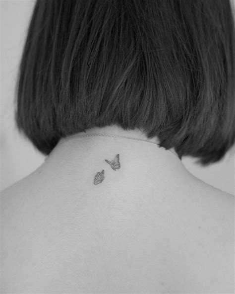 tiny butterfly couple tattooed on the upper back