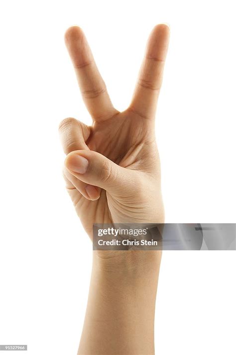 Woman Holding Two Fingers Up High Res Stock Photo Getty Images