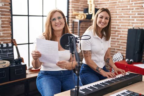 Mother And Daughter Musicians Singing Song Playing Piano At Music