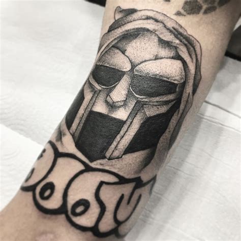 A Mans Arm With A Tattoo On It That Has An Image Of A Helmet And Glasses