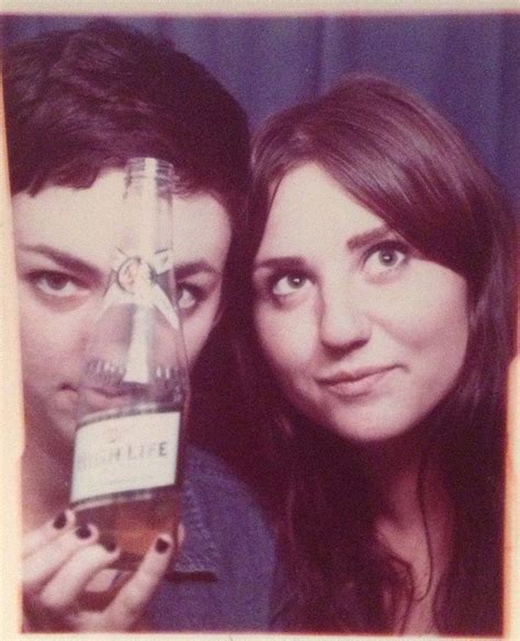 Two People Are Posing For A Photo With A Beer Bottle In Front Of Their Face
