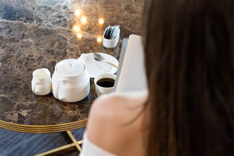 Premium Photo Woman Sitting Reading A Book Holding Cup Of Coffee