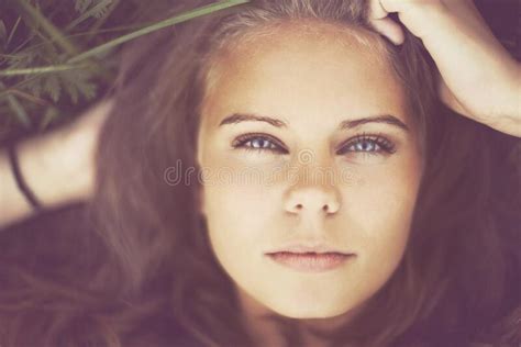 in touch with nature portrait of a gorgeous woman lying in the grass stock image image of