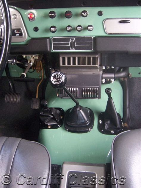 The Interior Of A Green Car With Black Leather Seats And Dashboard