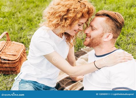 Side View Of Happy Redhead Couple Smiling Together At Picnic Stock