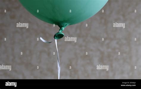 Soft Focus To Bottom Part Of Green Balloon With Rubber Tail Tied Knot