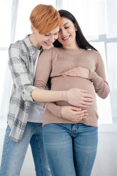 smi ling woman embracing pregnant girlfriend stock image image of