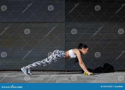 Fit Female In Workout Gear Doing Push Ups On Black Background Outdoors