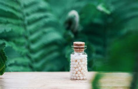 Premium Photo Bottles Of Homeopathic Globules On Green Fern