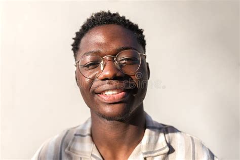 Headshot Of Young Happy And Smiling Black Man Wearing Glasses Outdoors