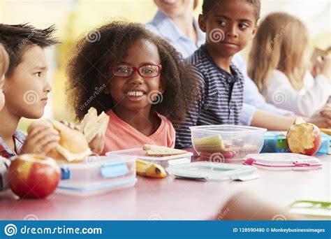 School Kids Eating Packed Lunches Together At A Table Stock Photo