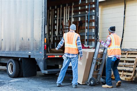 Two Workers With A Truck Moving Large Box Stock Photo Download Image