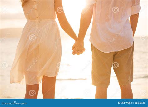 Paar Paarhändchenhalten Bei Sonnenuntergang Auf Strand Stockfoto Bild Von Geliebte Paare