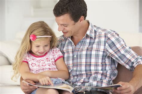 Father And Daughter Reading Book At Home Stock Image Image Of