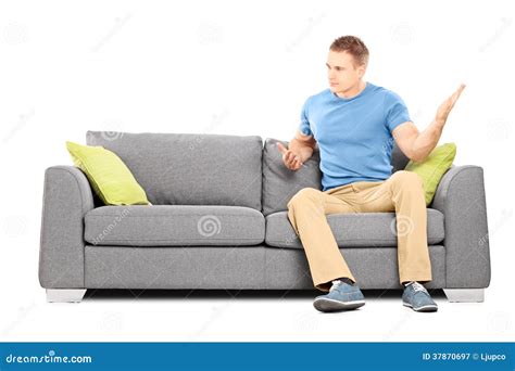 Angry Man Sitting On Couch And Violently Swinging His Hand Stock Image