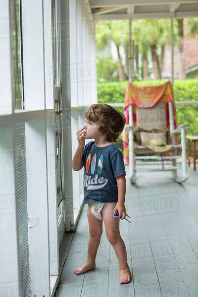 Curious Caucasian Boy Wearing Diaper Near Screen Door Stock Photo
