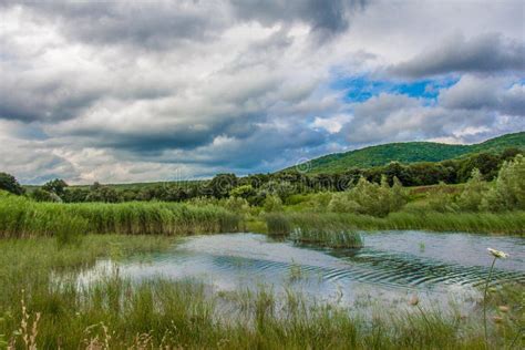 Clouds Over Hills Green Grass And Water Stock Image Image Of